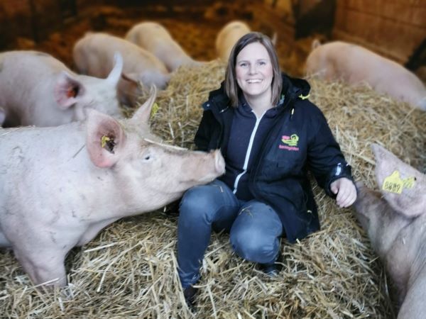 Lina Danlid Burke, ägare av Backegårdens suggring sitter i halmen bland grisarna.